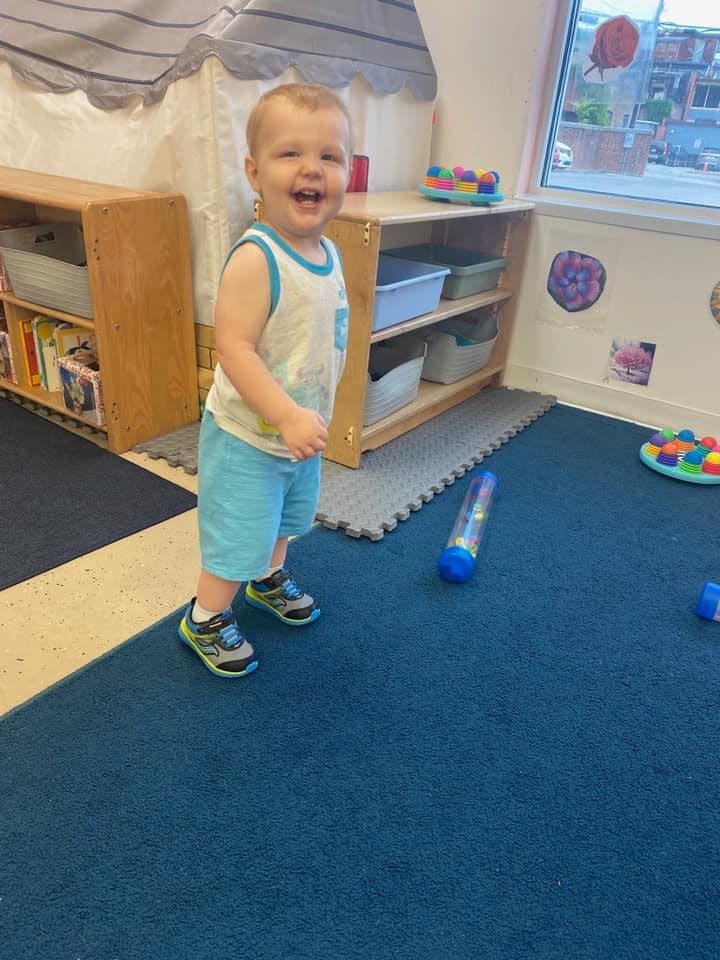 Child standing on a blue carpet in a room