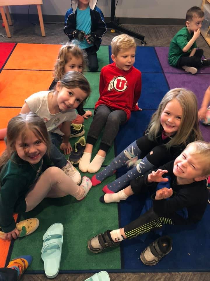 Group of children sitting on a colorful rug