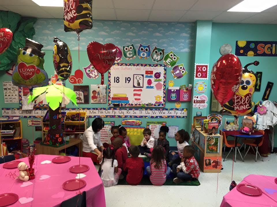 Adult and children sitting on the floor in a classroom