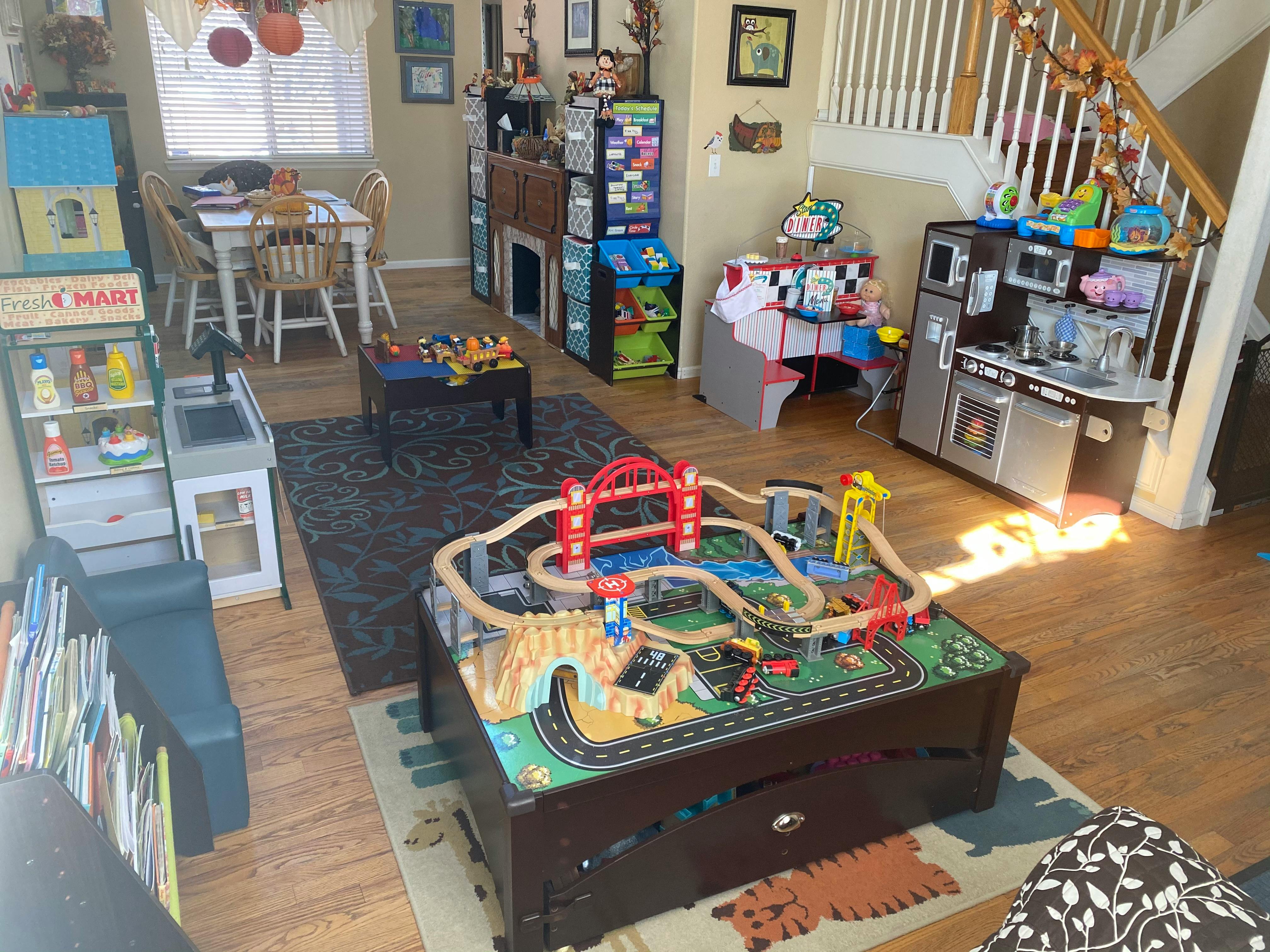 Playroom with a train table, toy kitchen, and dining area