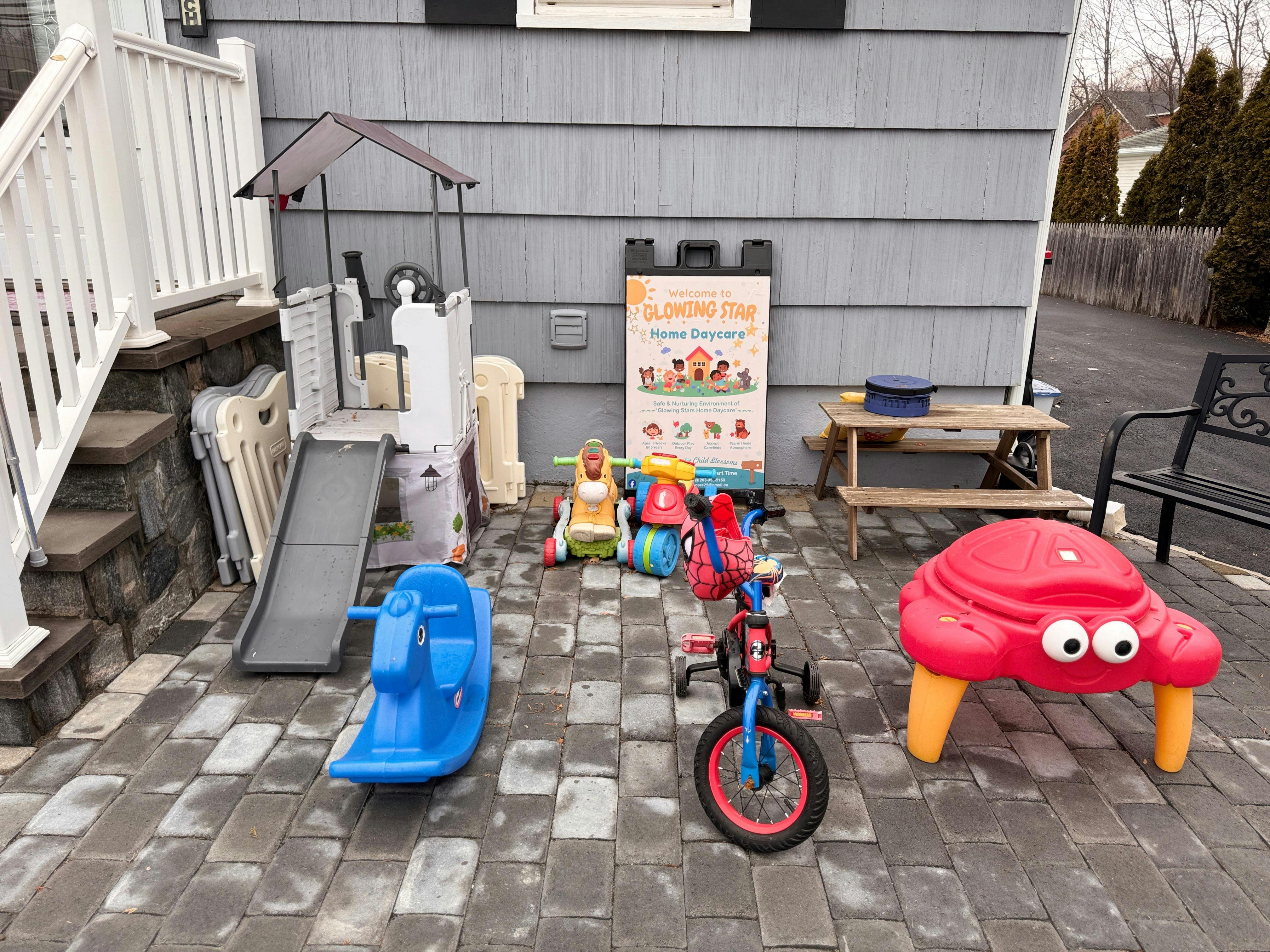 Children's outdoor play equipment including a slide, tricycle, and rocking horse