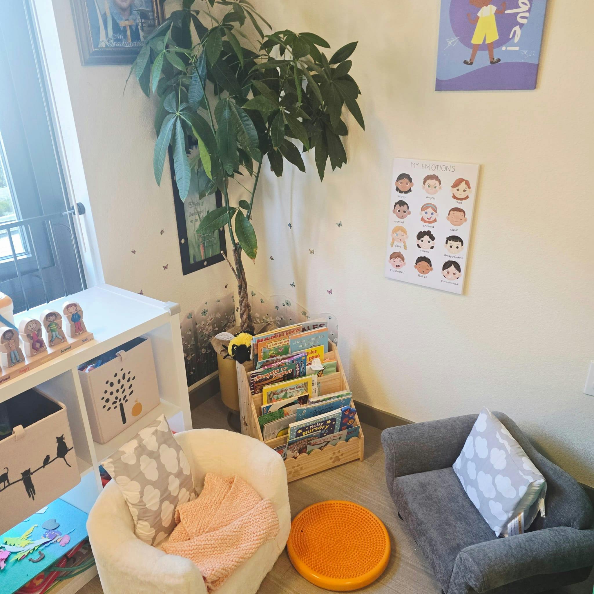 Children's reading nook with small chairs, book display, and plant