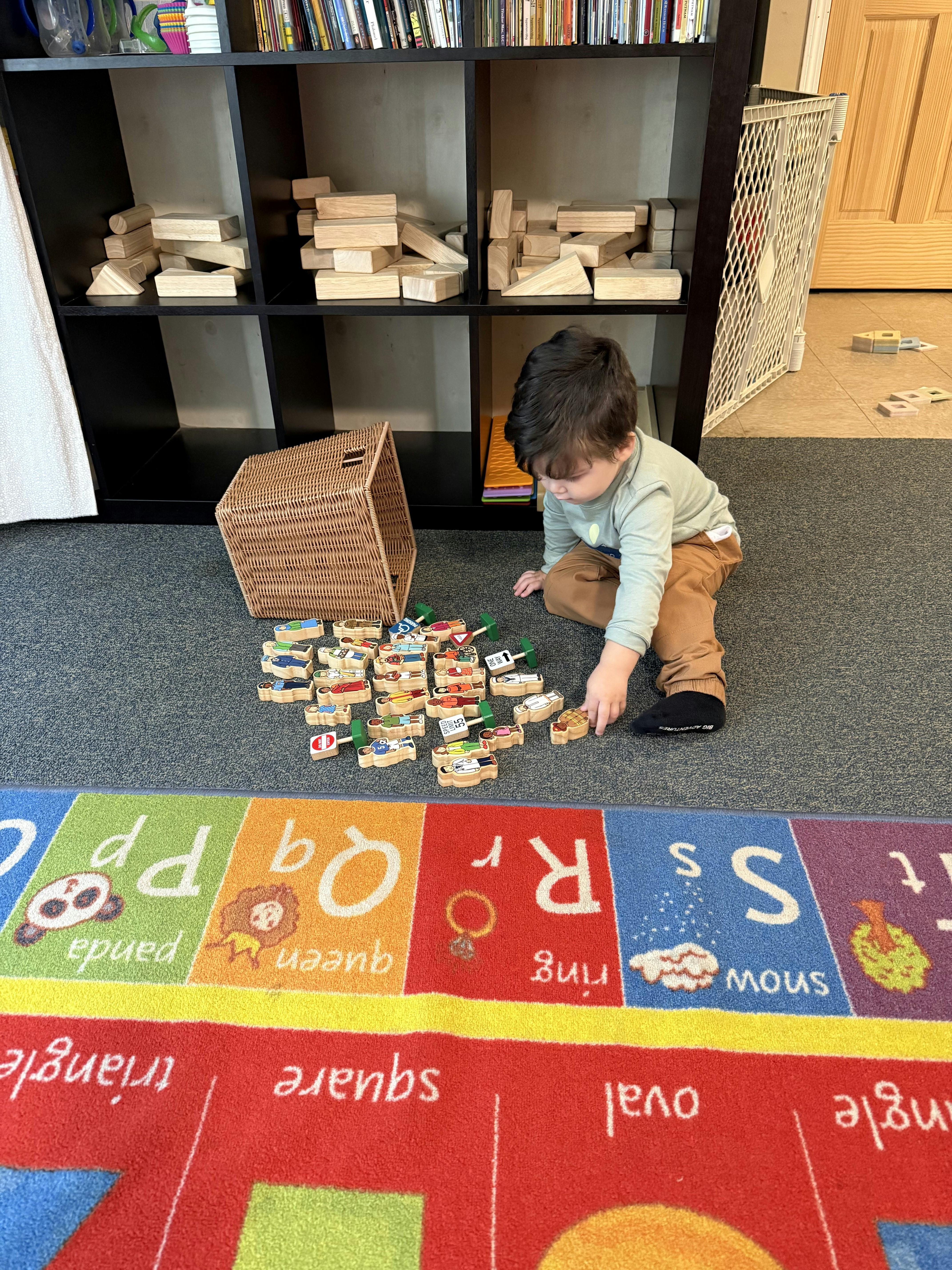 Child playing with wooden toy cars on a rug