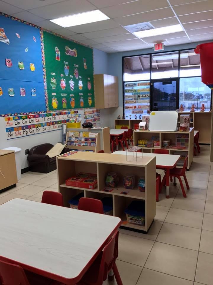 Classroom with small tables and chairs, shelves, and bulletin boards