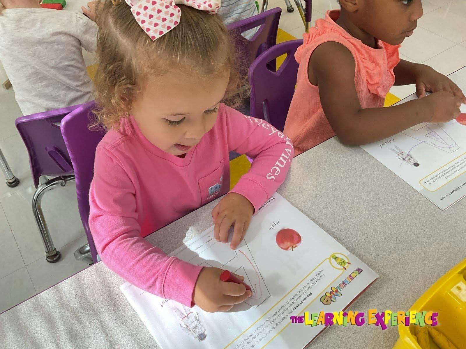 Children coloring in workbooks at a table