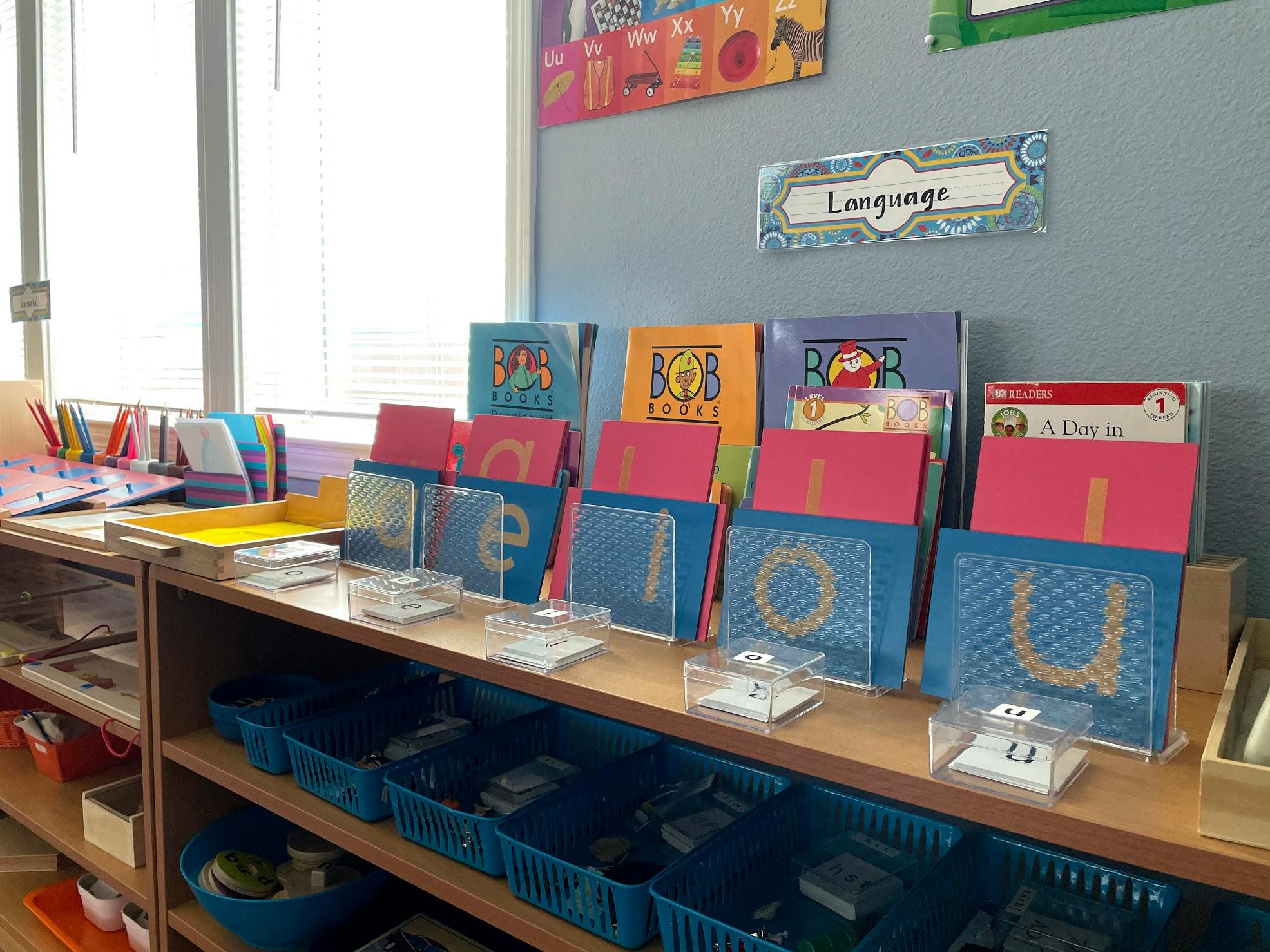 Classroom shelf with alphabet letter cards and books, "Language" sign above
