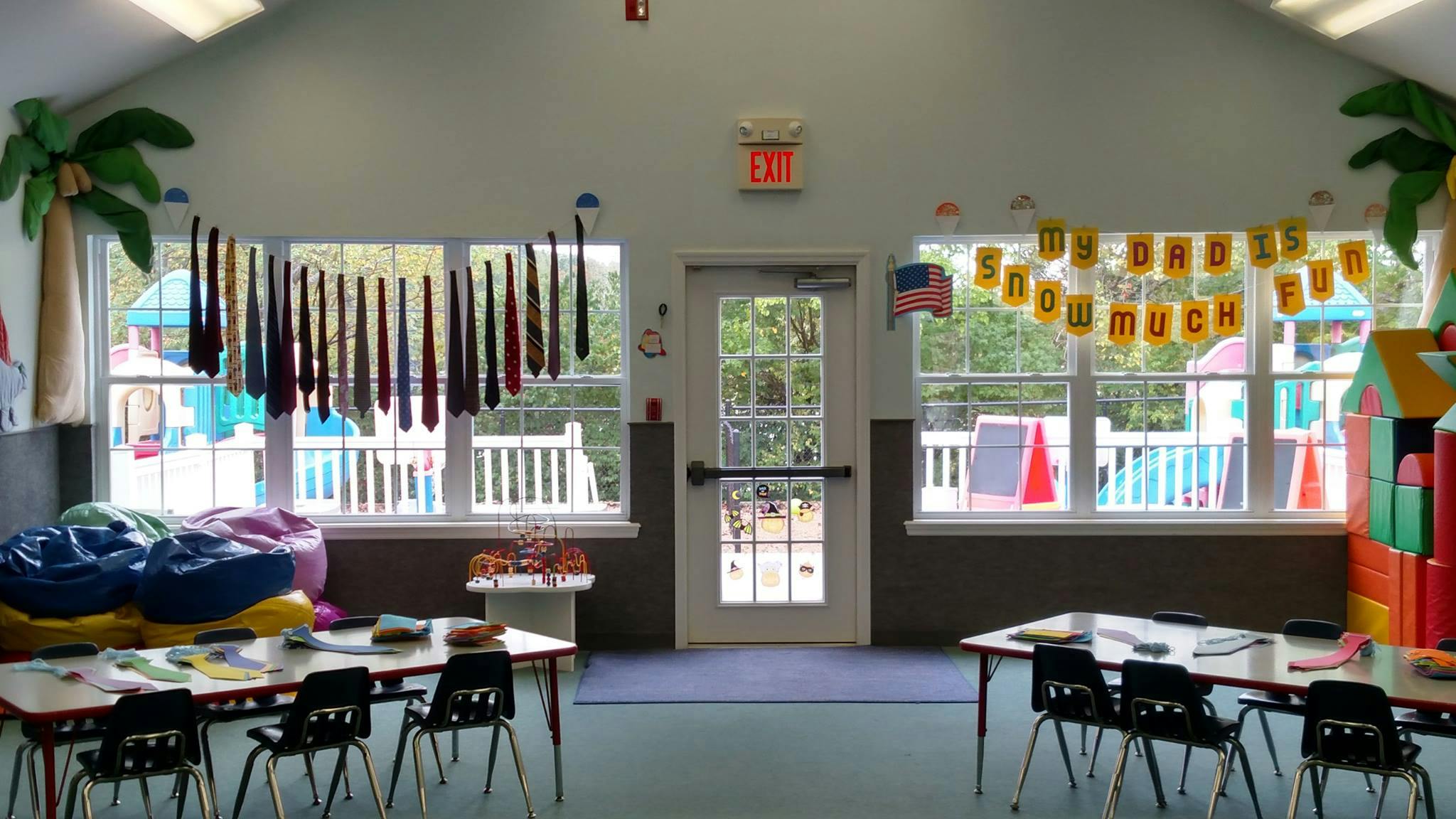 Classroom with tables and chairs, windows looking out to a playground
