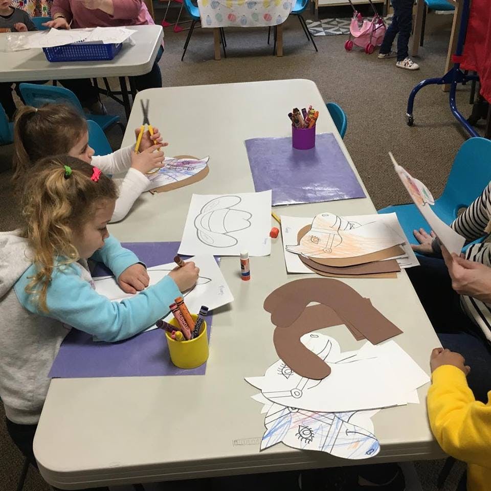 Children at a table doing crafts with crafts and paper crafts