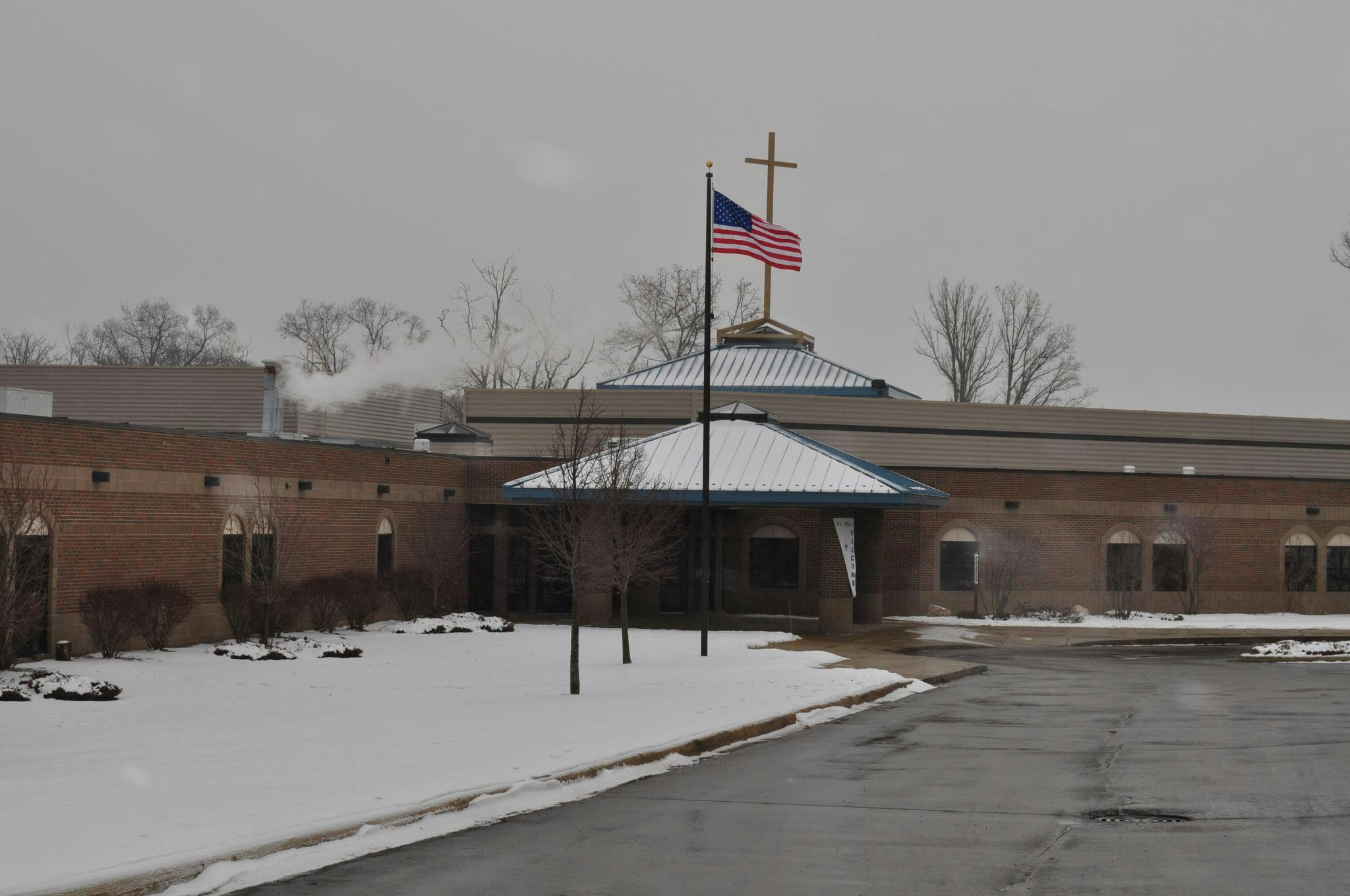 Building with a cross and American flag on the roof in winter