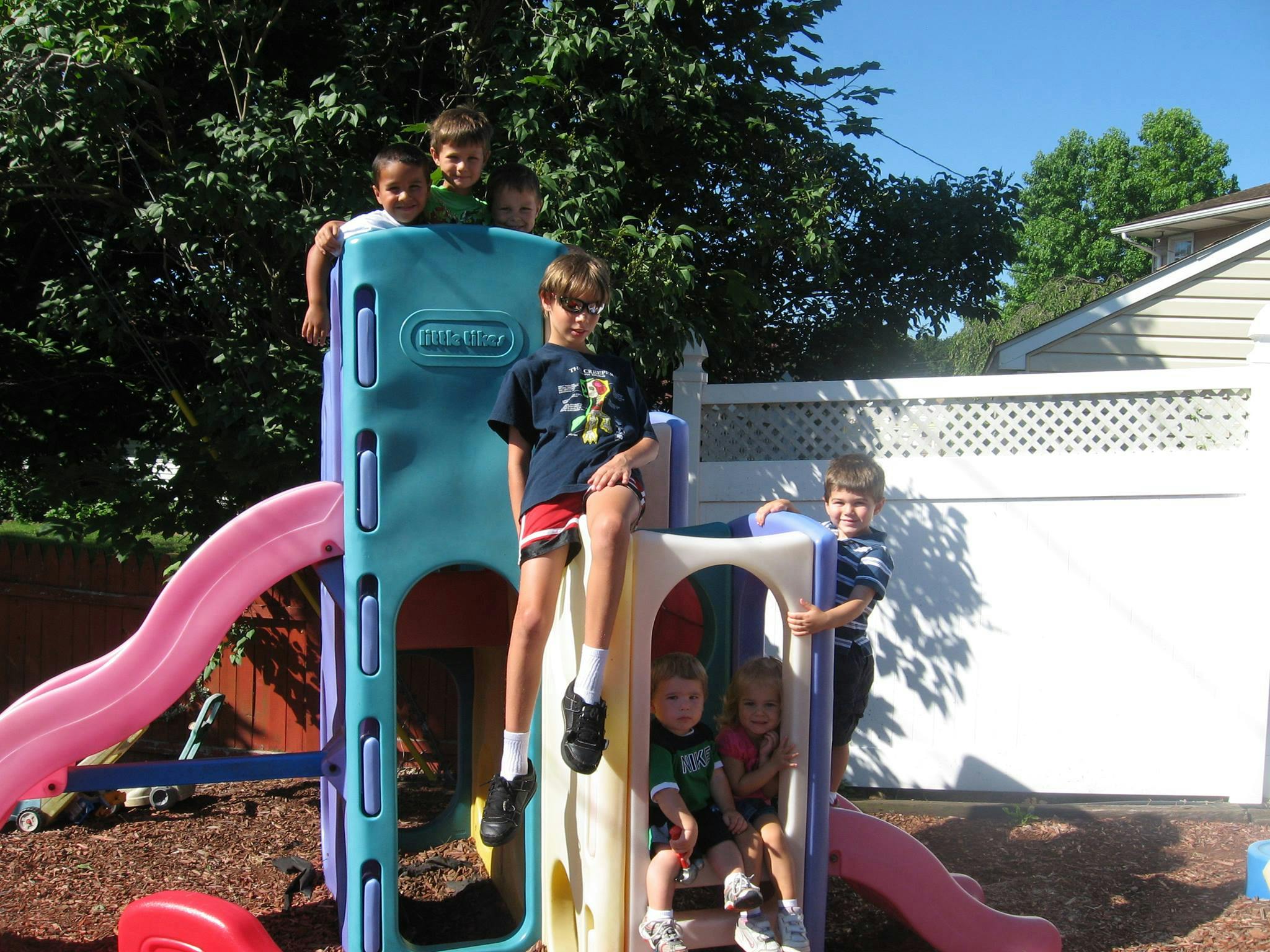 Children playing on a colorful outdoor playset with slides
