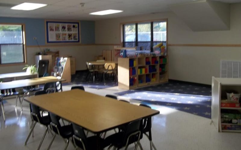 Classroom with tables, chairs, and cubbies