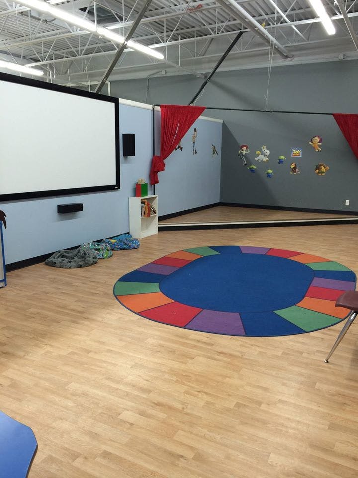 Classroom with a large projection screen and a colorful circular rug