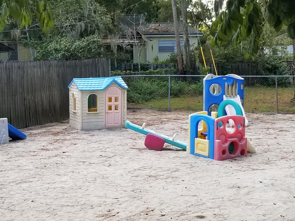 Playground with a playhouse, seesaw, and climbing structure