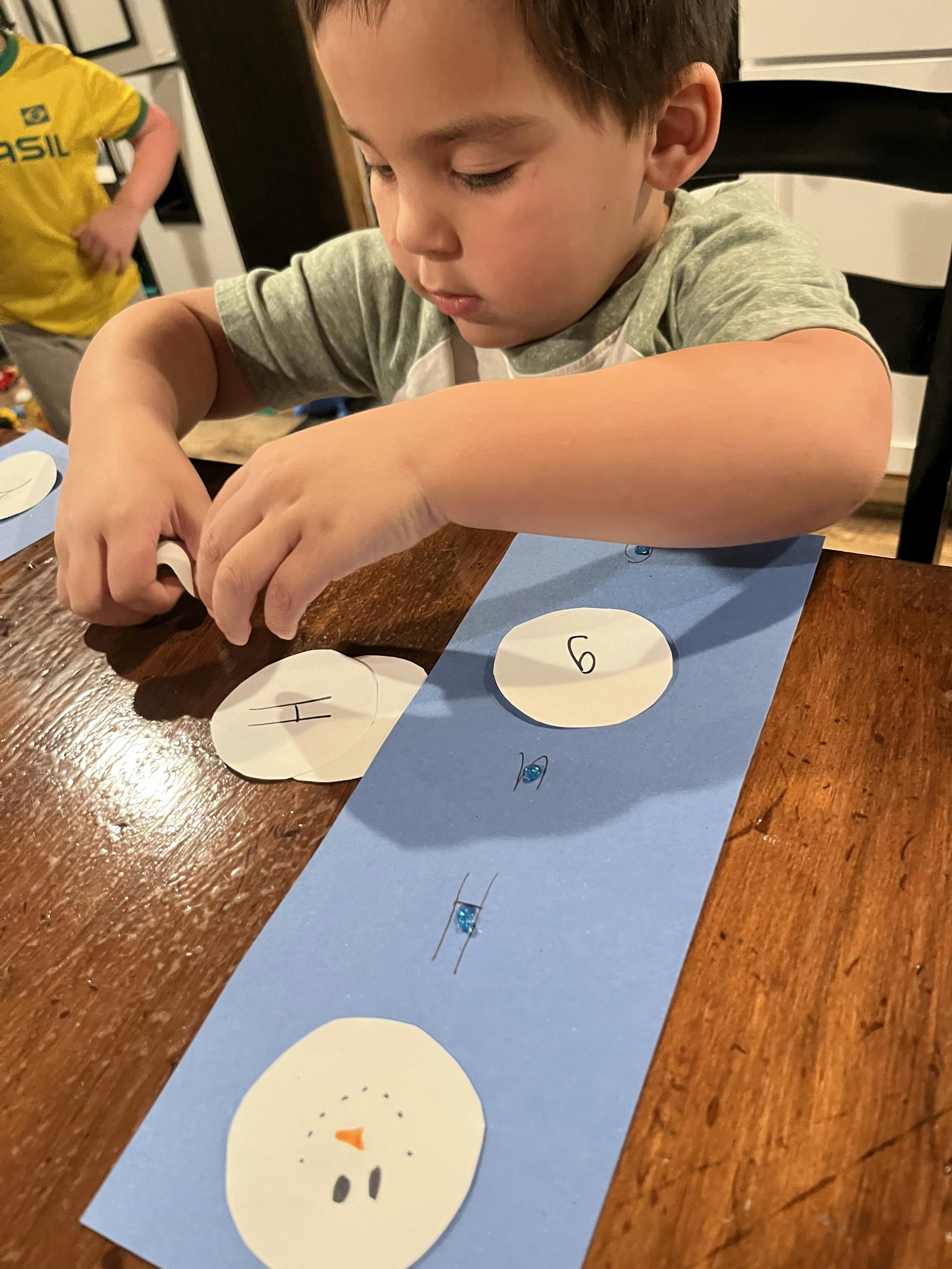 Child crafting paper snowman