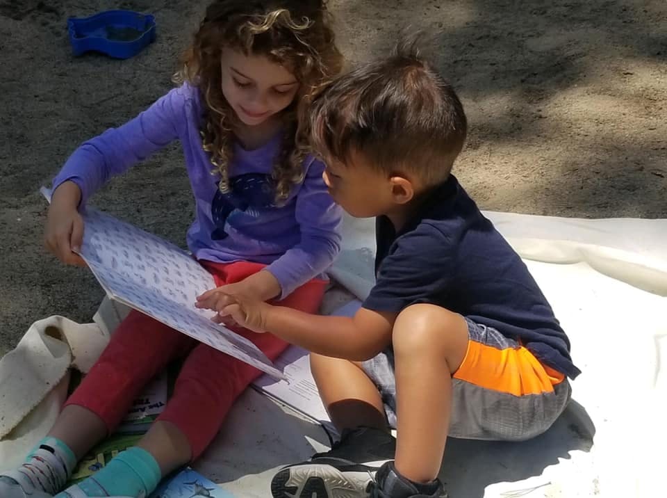 Two children looking at a book together