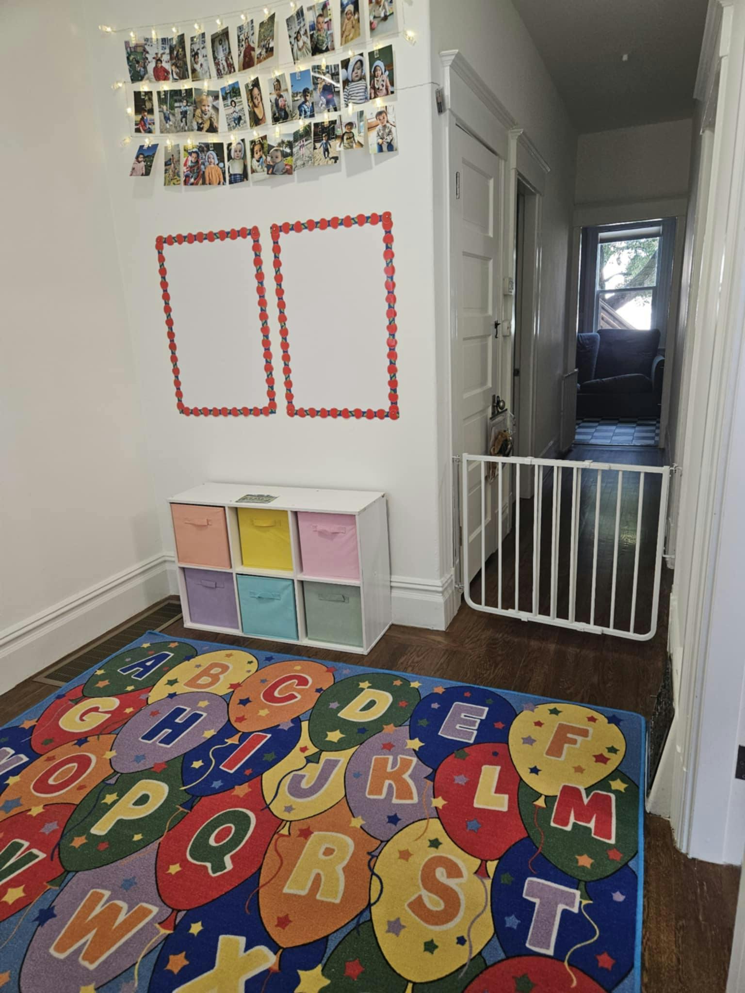 Child's play area with an alphabet rug, storage cubbies, and wall decorations