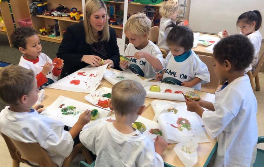 Adult and children painting in a classroom