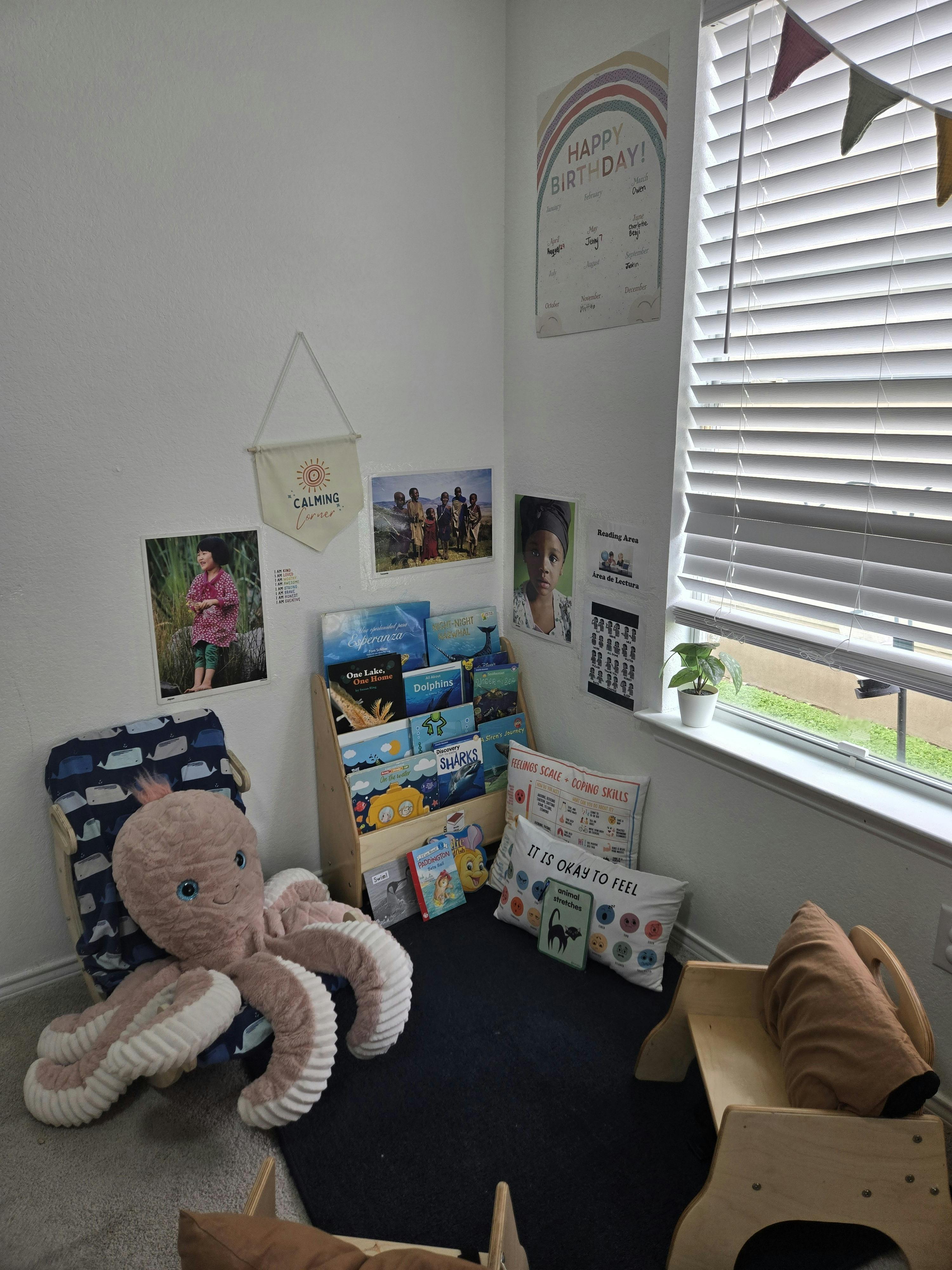 Children's reading nook with a bookshelf, pillows, and a large octopus plush toy