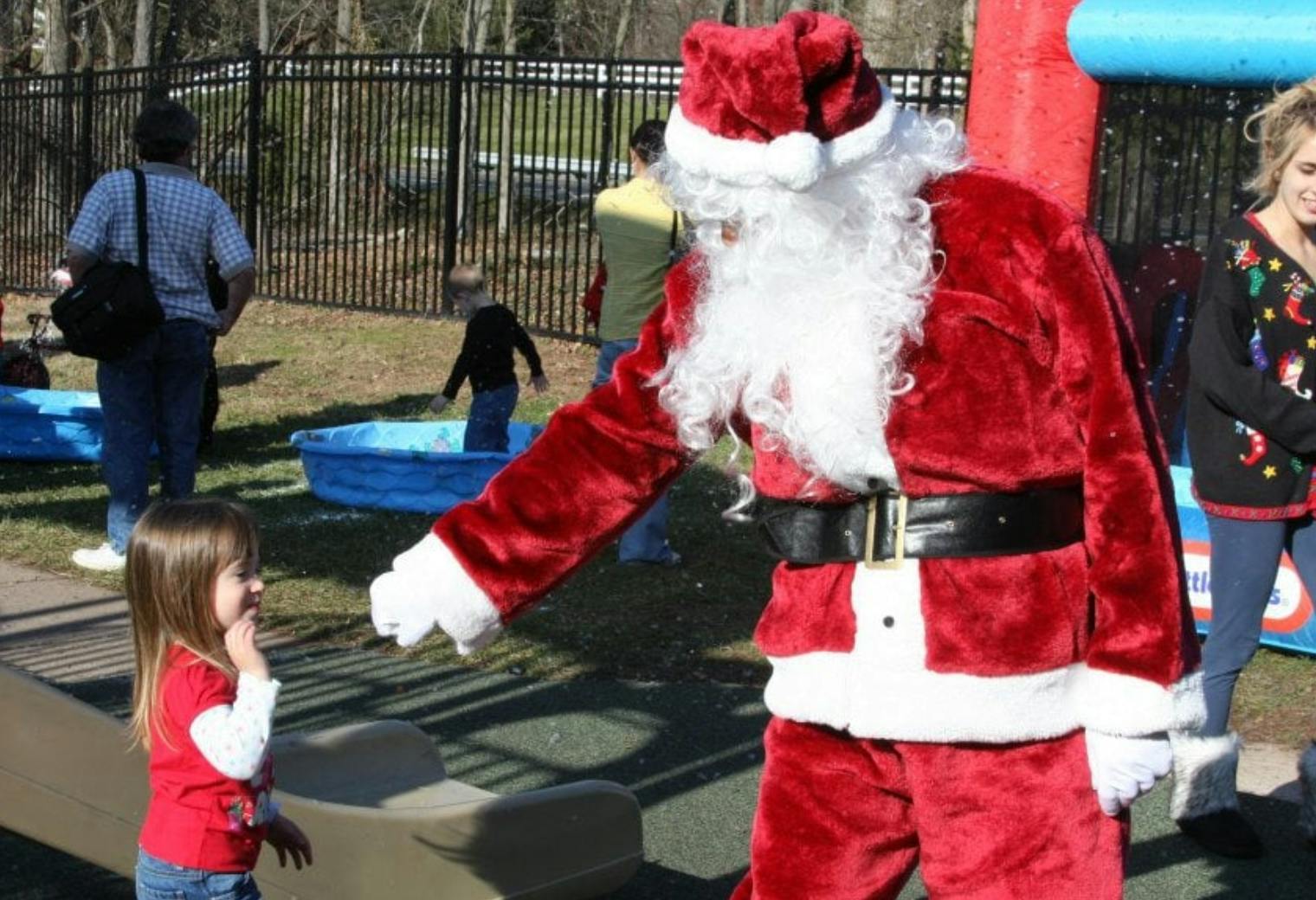 Person in Santa costume interacting with a child