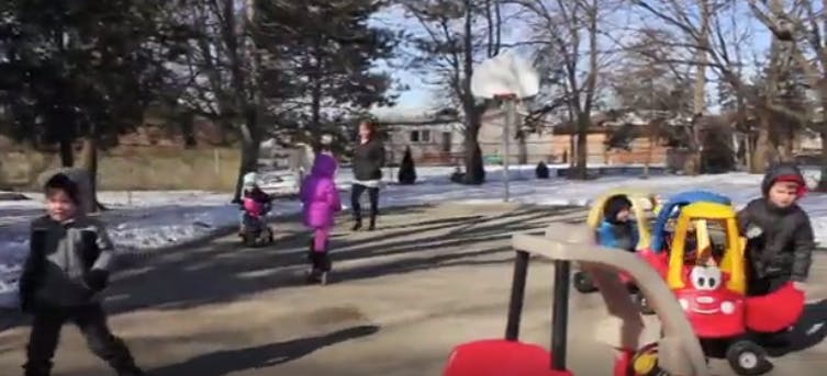 Children playing outdoors in winter with ride-on toys