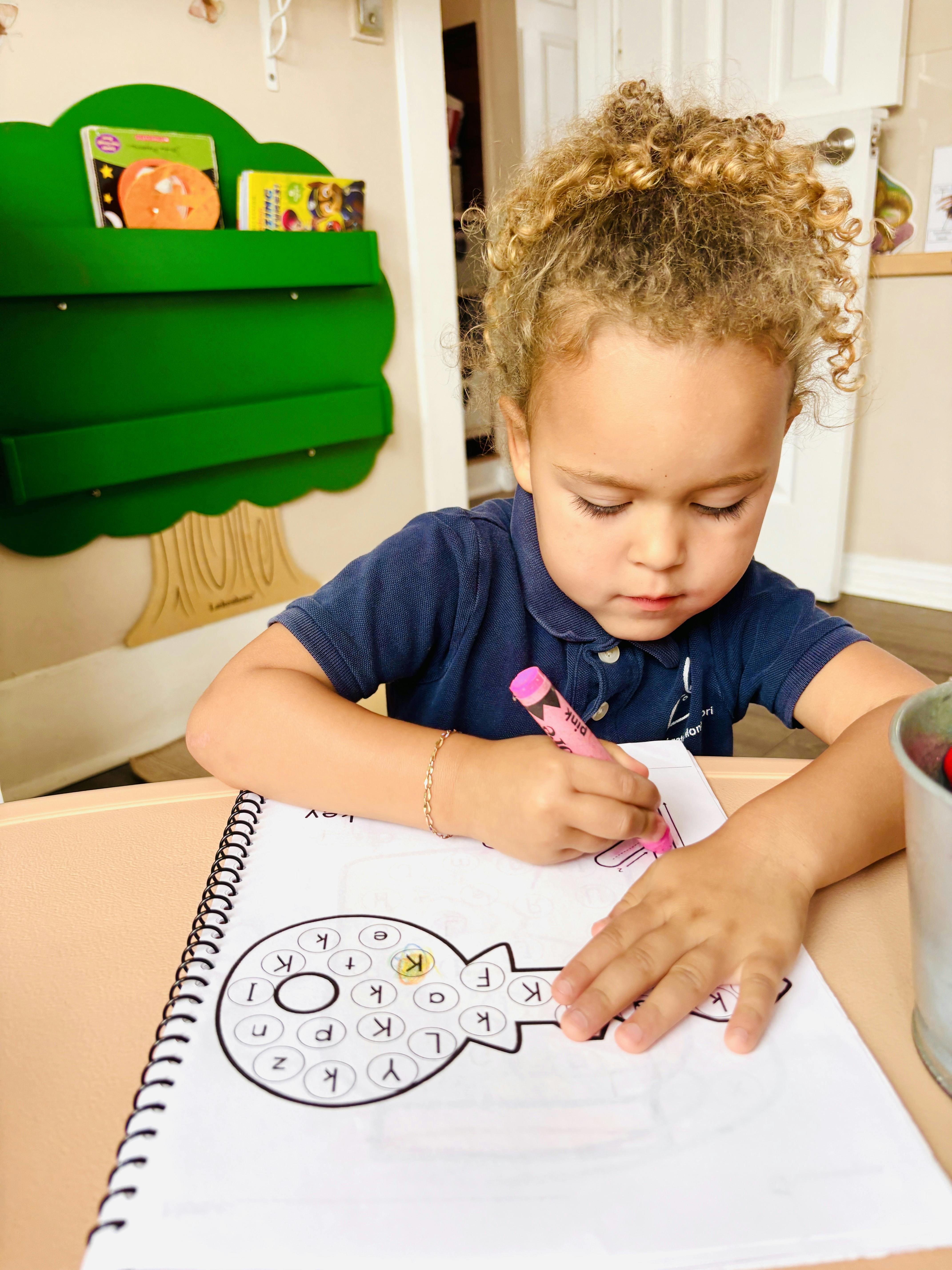 Child coloring in a key-shaped activity sheet