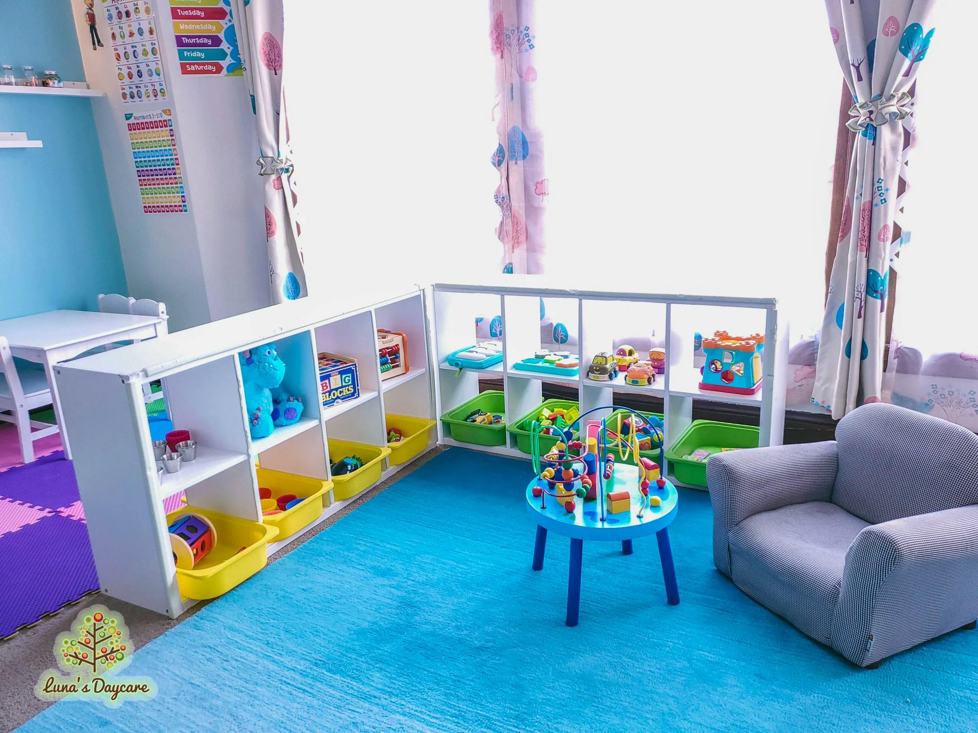 Playroom with toy shelves, a small table with toys, and a child-sized armchair