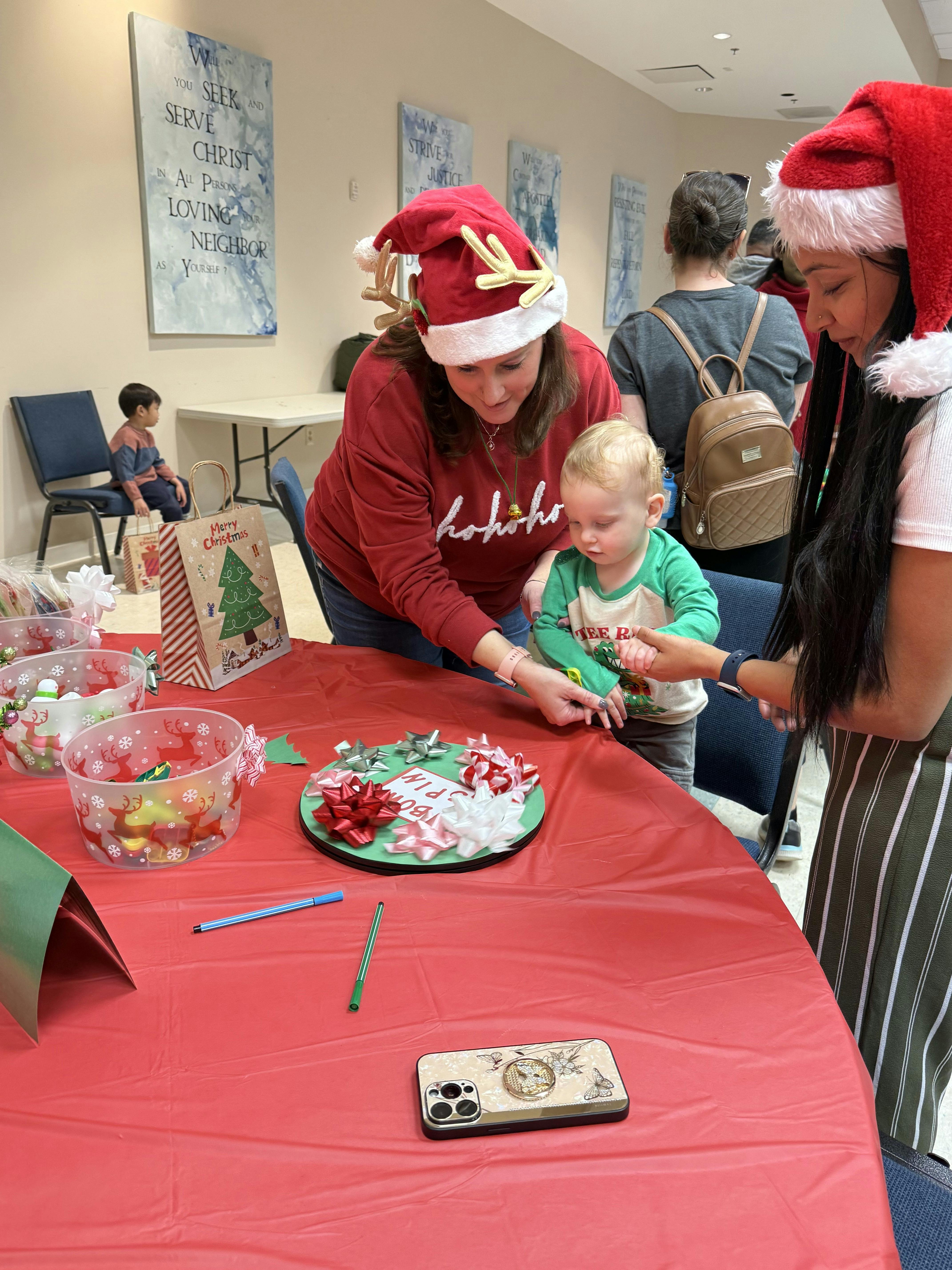 People and a child at a table with bows and gift bags