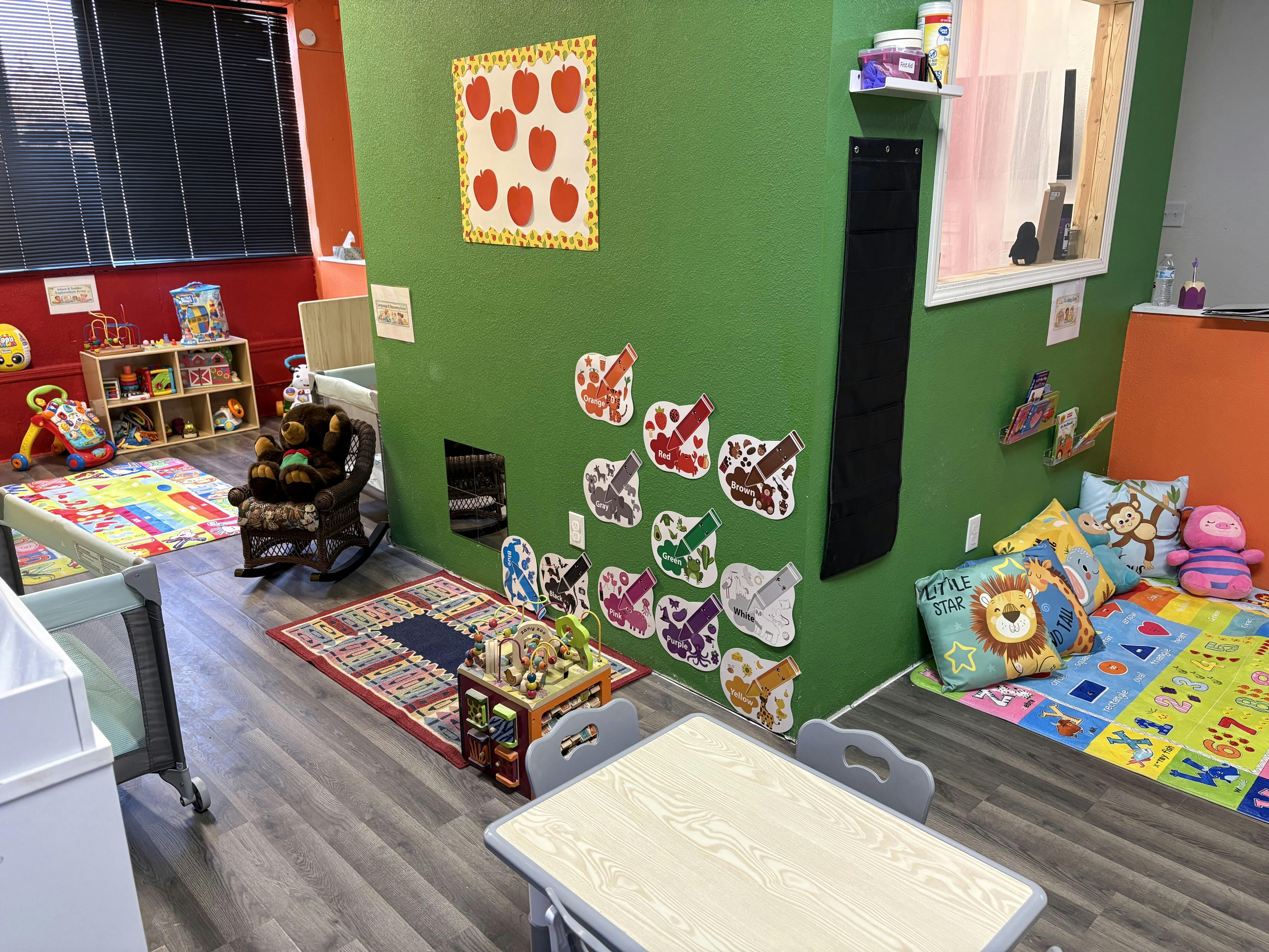 Children's play area with toys, colorful rugs, and wall decorations
