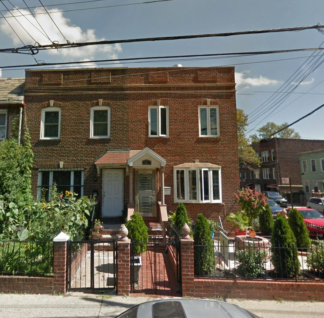 Brick building with two front doors and a fenced yard
