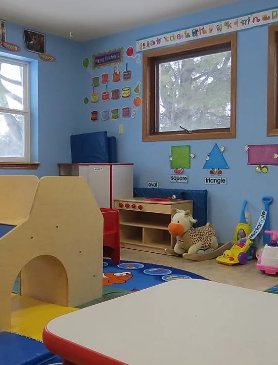 A classroom with blue walls, windows, and colorful educational decorations