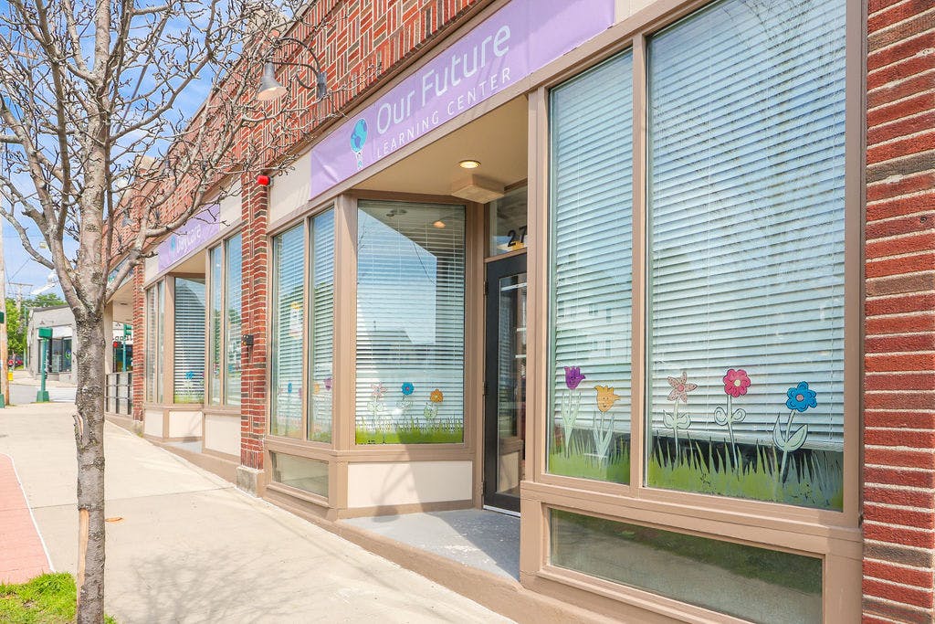 Storefront with large windows and a sign that reads "Our Future"