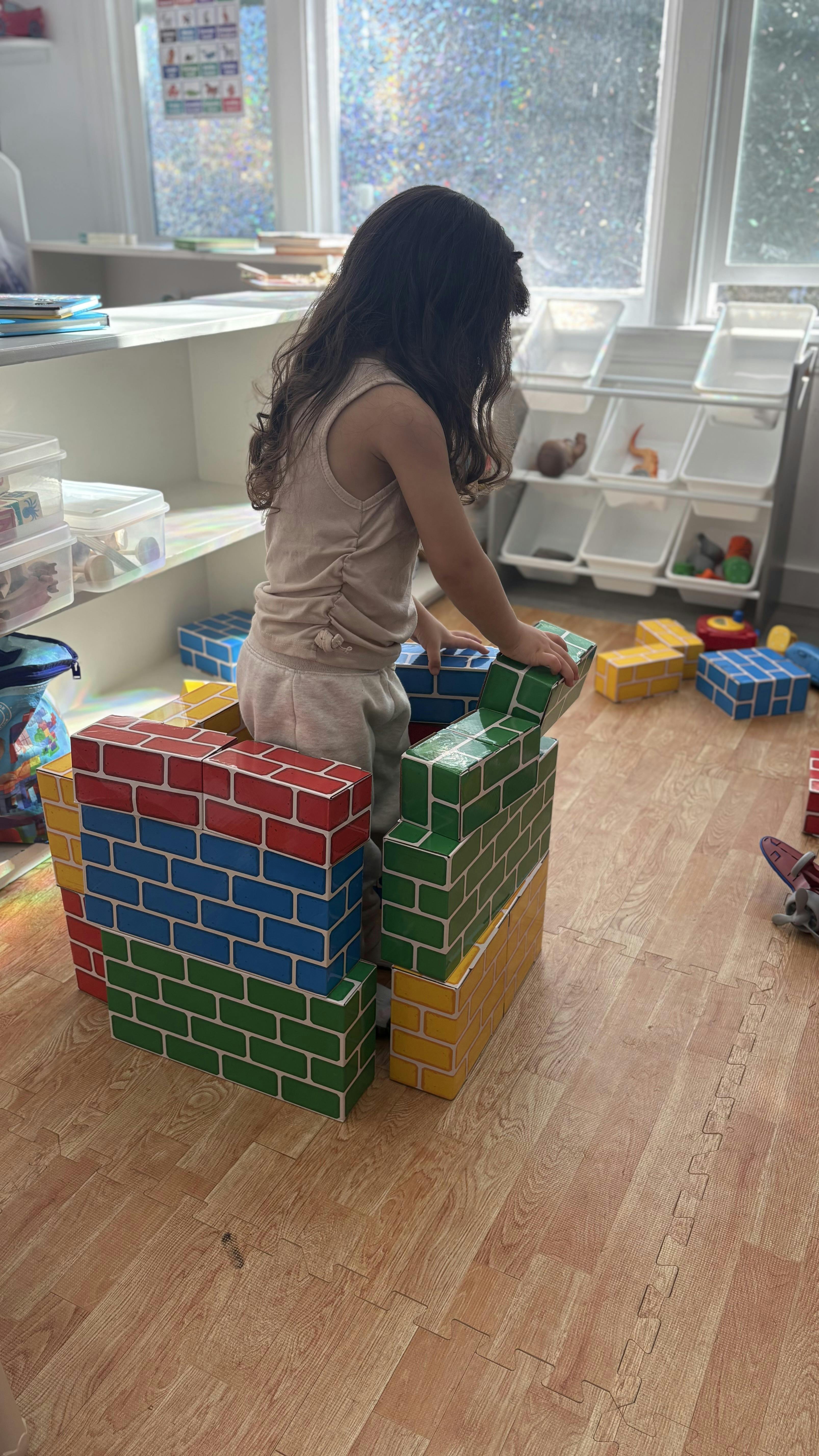 Child playing with colorful building blocks in a classroom