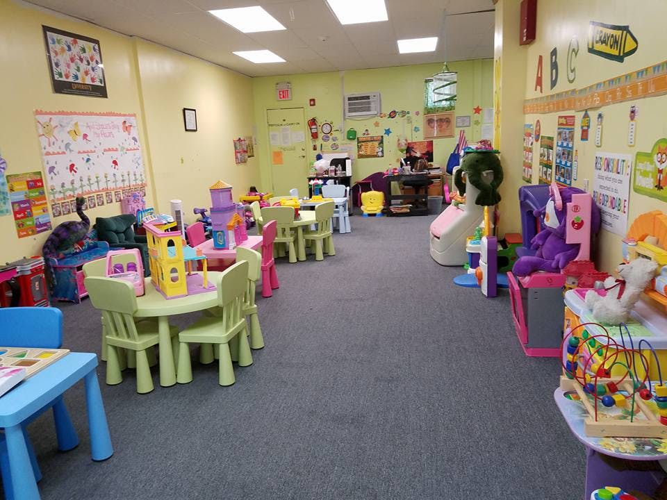 Playroom with small tables and chairs, toys, and decorations on the walls