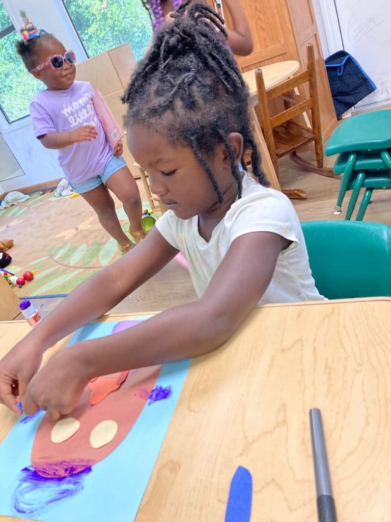 Child creating art at a table