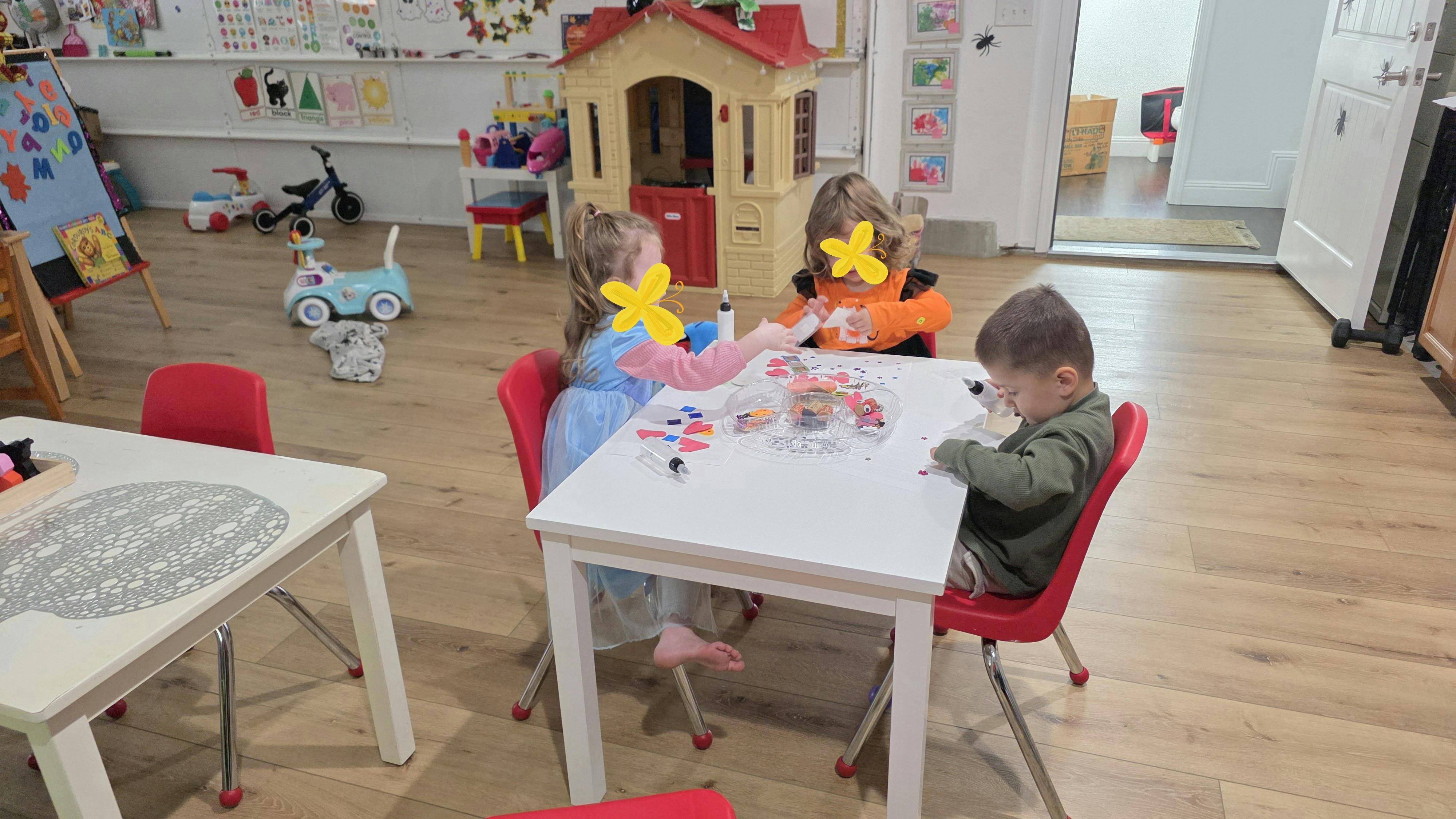 Three children sitting at a table drawing