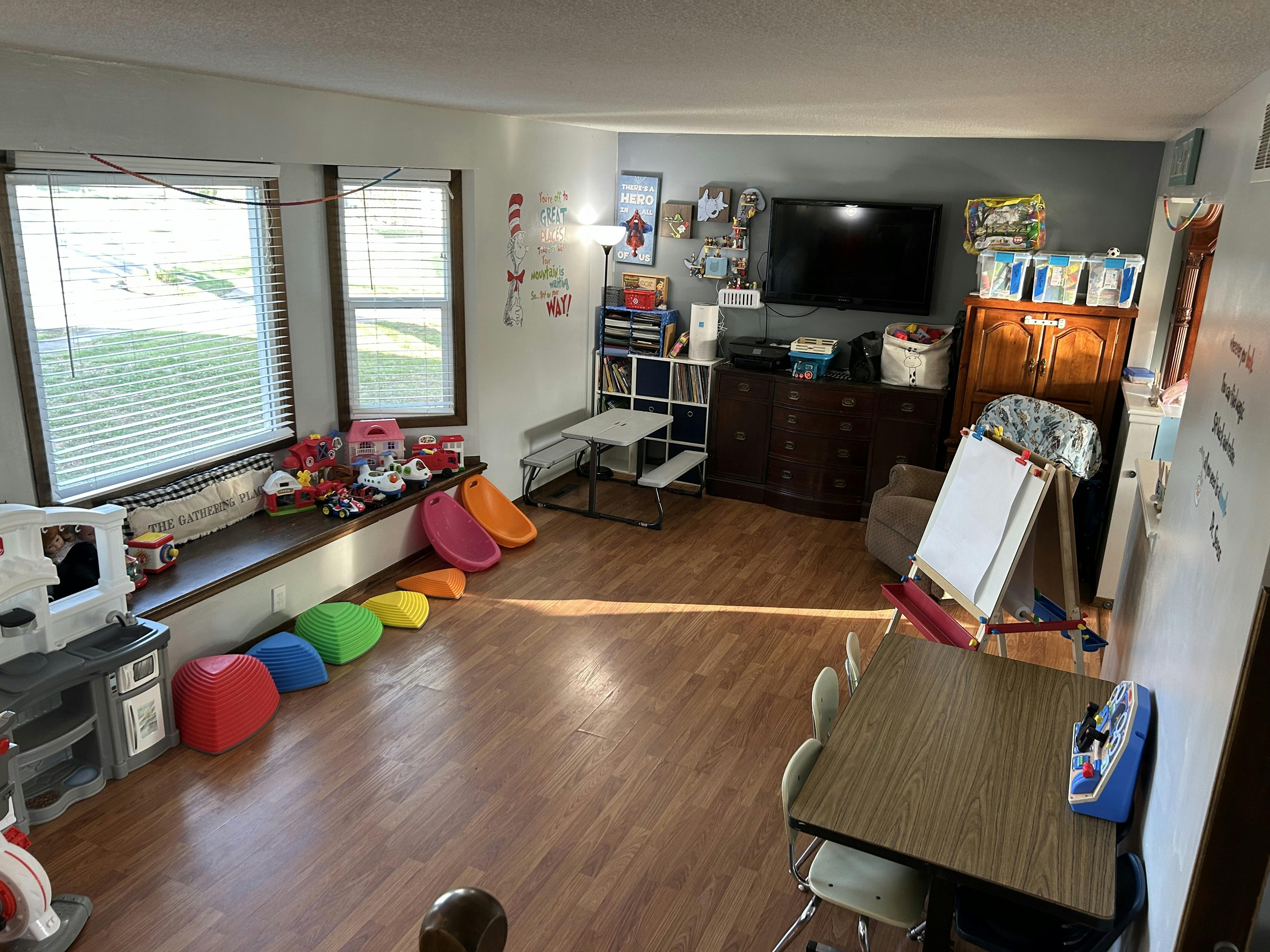 Living room with a window seat, television, and children's play items