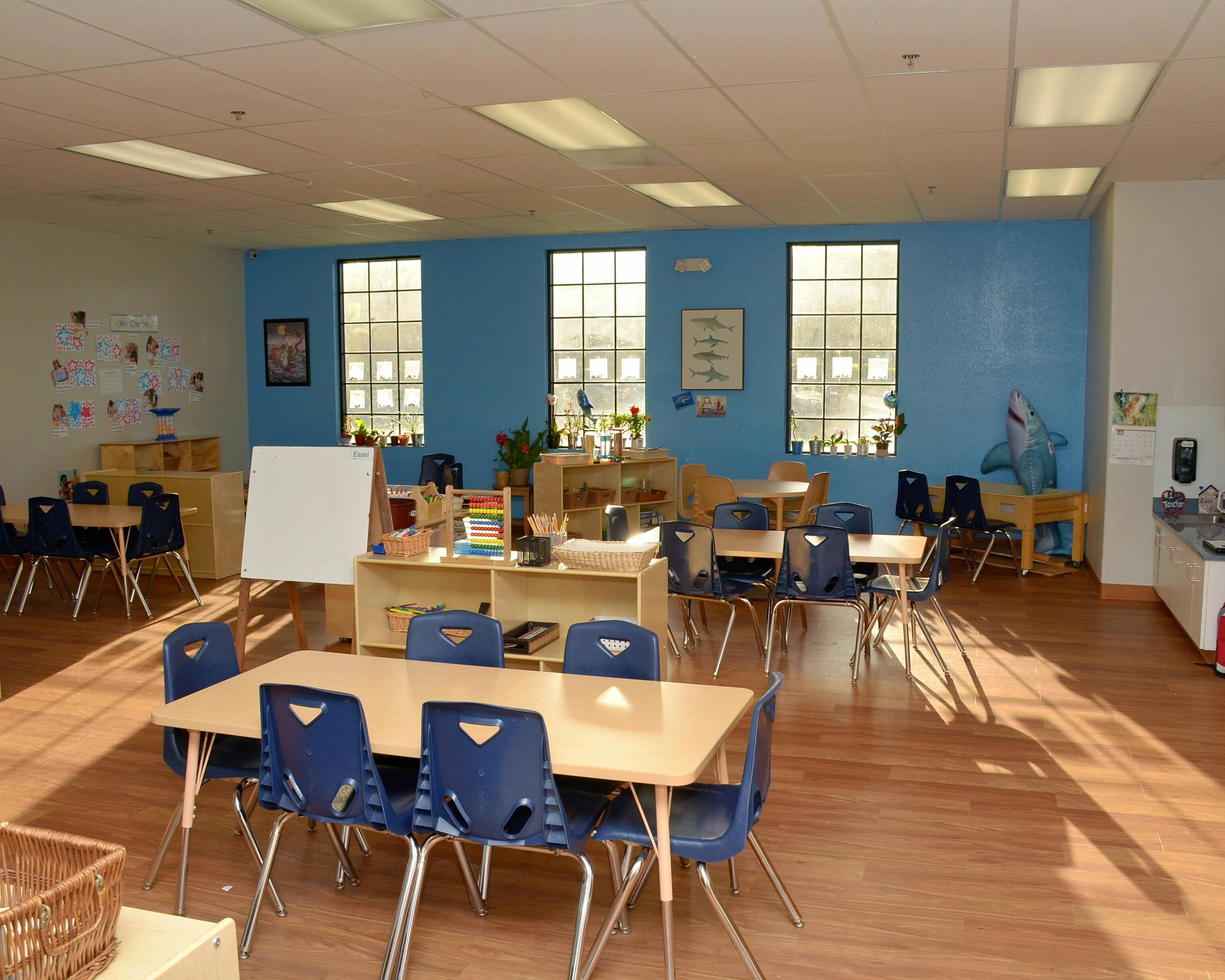 Classroom with small tables and blue chairs