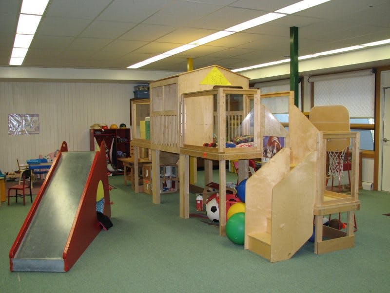 Indoor playground with a slide and wooden play structure
