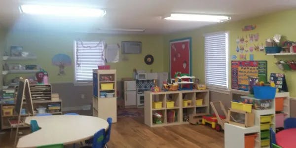 Classroom with tables, chairs, and shelves filled with learning materials