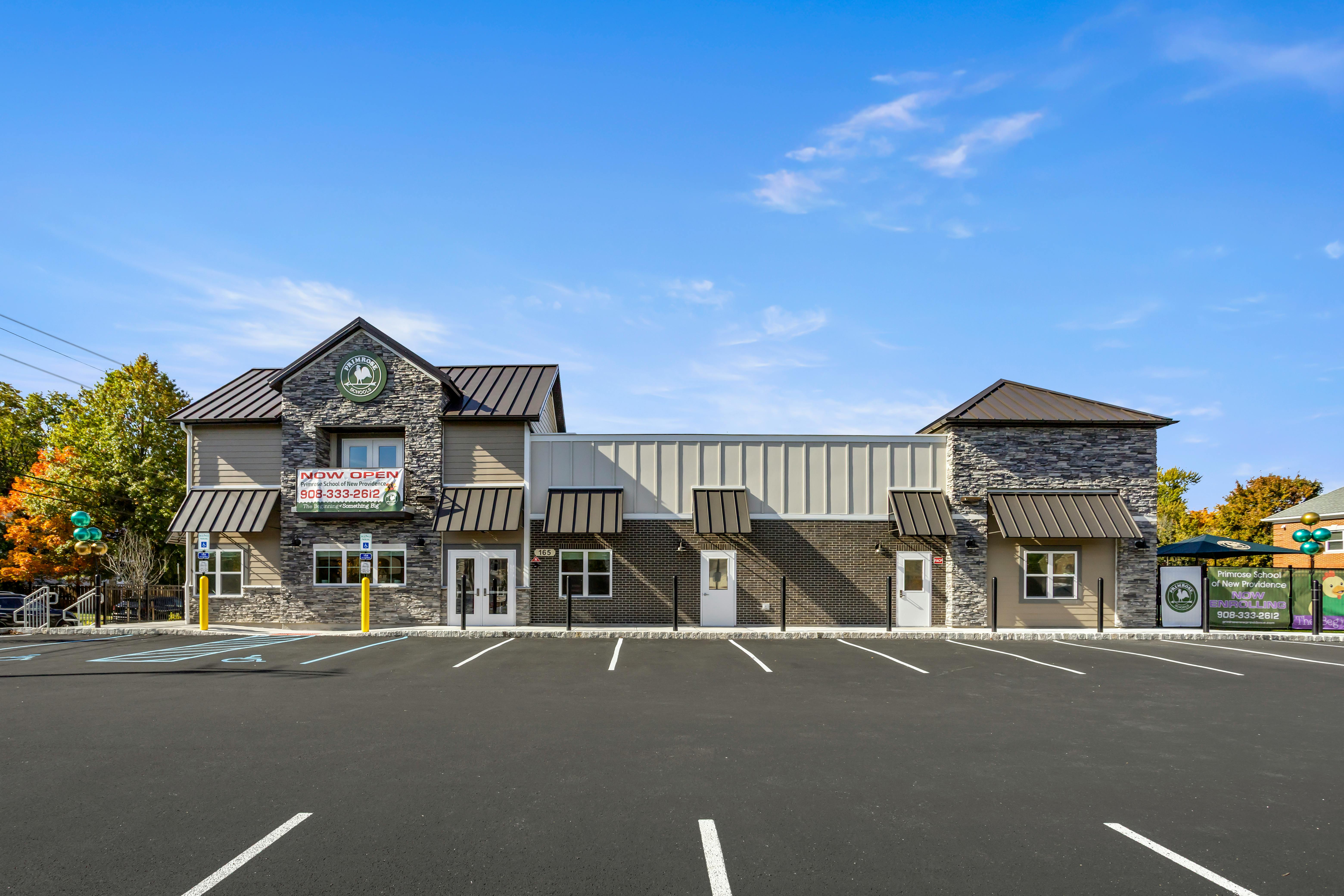 Exterior view of Primrose School building with a paved parking lot in front
