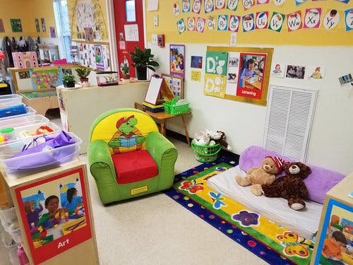 Child's armchair and bed with stuffed animals in a classroom