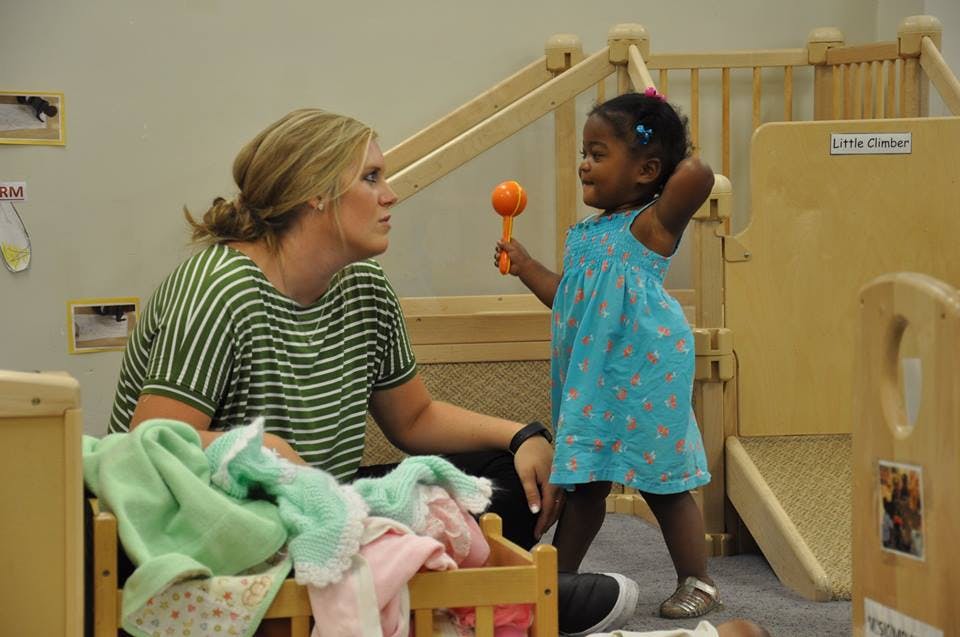 Adult and child interacting in a classroom
