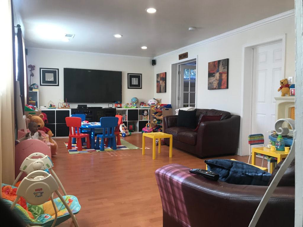 Living room with a large TV, couches, and a child's table and chairs