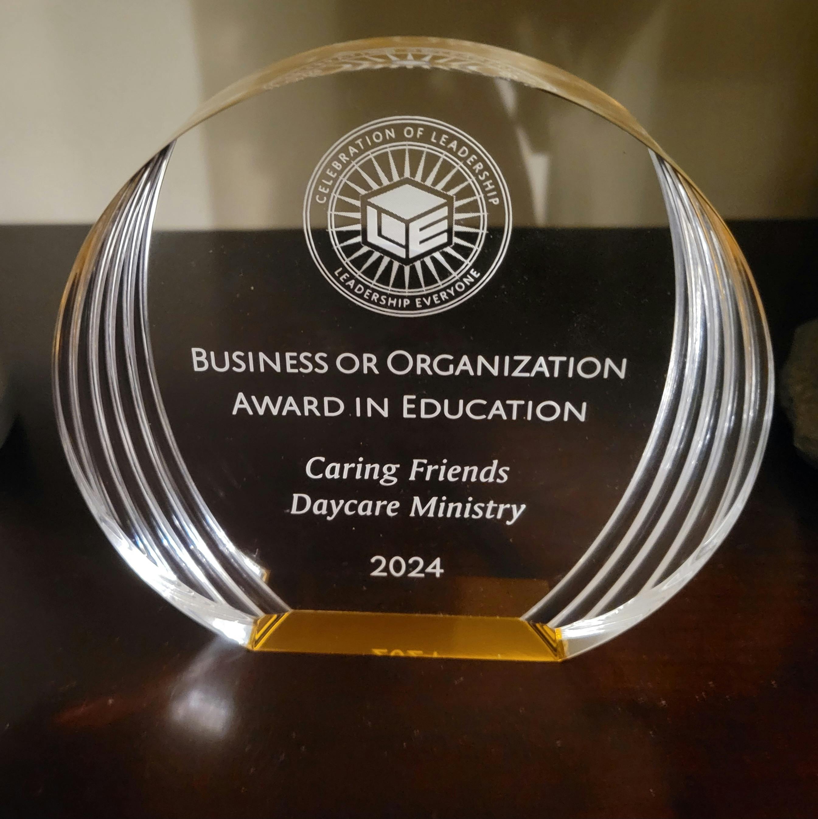 Clear award trophy with text "Business or Organization Award in Education"
