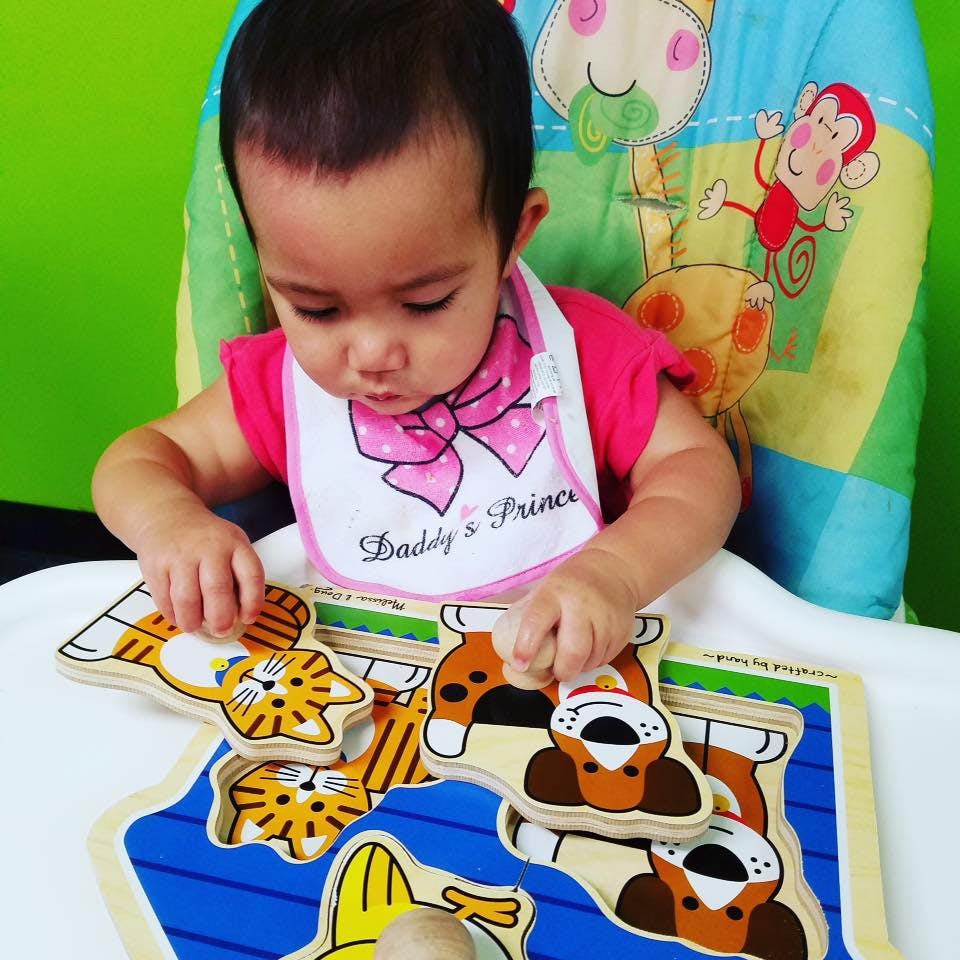 Child playing with a wooden animal puzzle