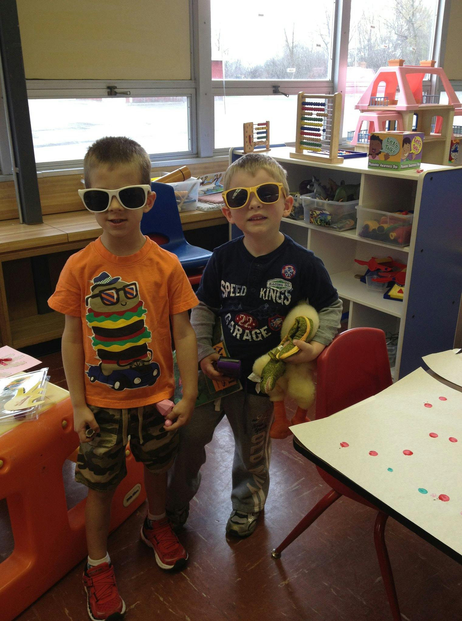 Two children wearing sunglasses in a classroom