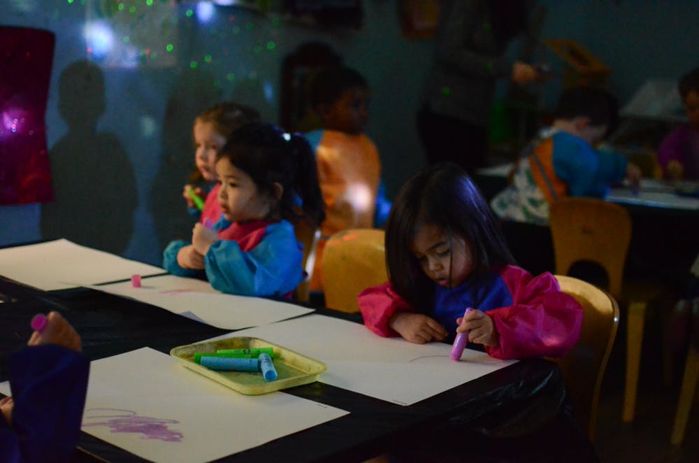 Children drawing at a table in a classroom