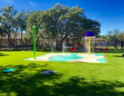 Splash pad with water spraying in a grassy area
