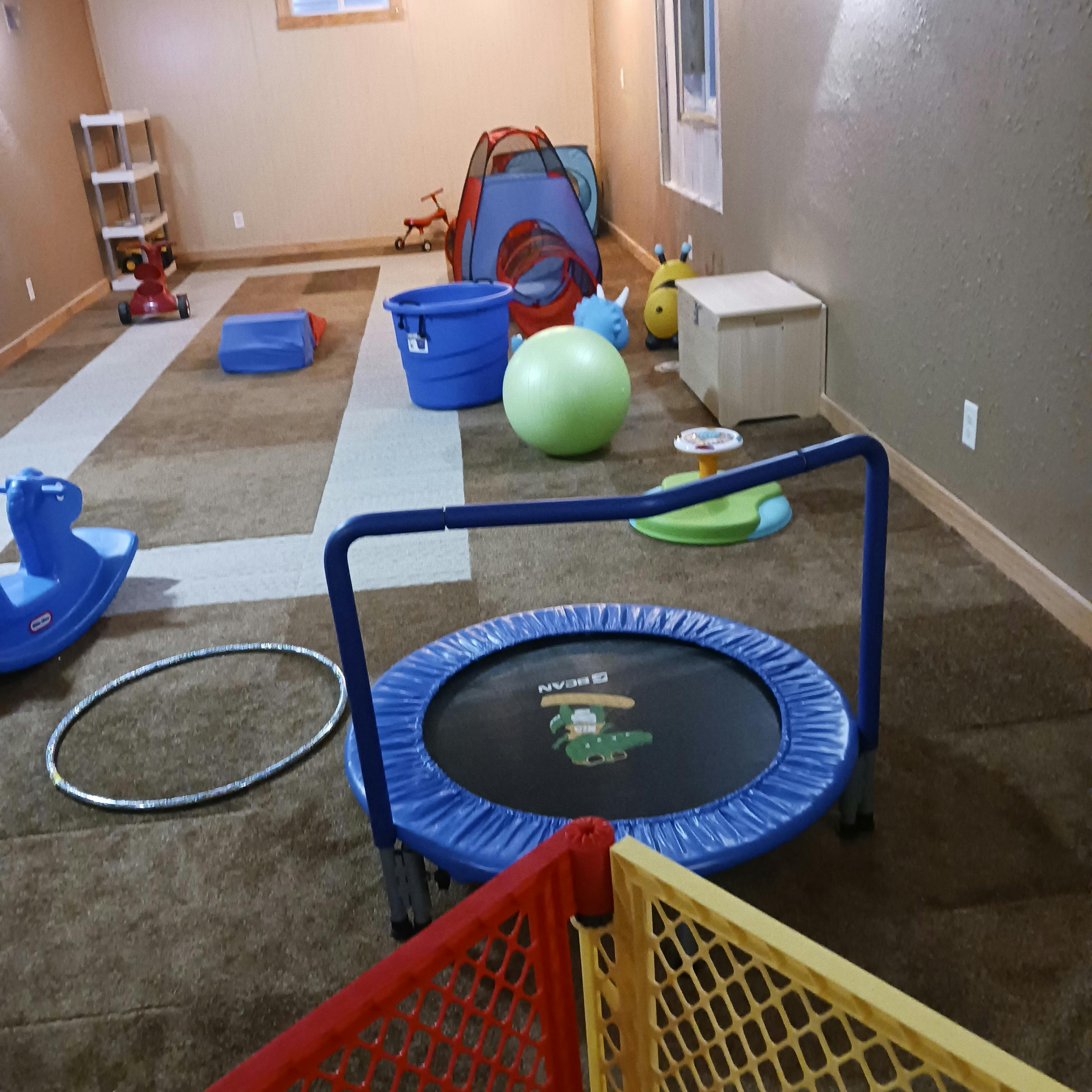 Playroom with a trampoline, exercise ball, and various toys