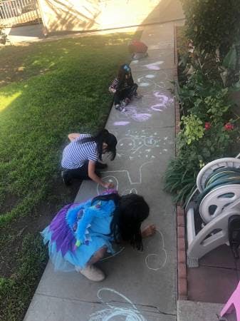 Children drawing with chalk on a sidewalk